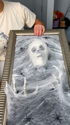 a person is holding up a painting that looks like it has been made to look like a skeleton