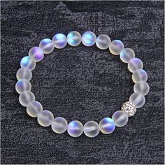 This Mermaid Bracelet Is Uniquely Designed With One Crystal Disco Ball Bead With A Sparkle That Will Surprise You. You Have To Experience One To Believe It! The Hypnotic Frosted White Moonstone Color Tells Tales Of Bringing Lovers Together. It Is The Color Of Choice For Weddings, Engagement, Anniversaries, Or As A Valentine's Day Gift To A Lover. This Stretchable Bracelet Is 7.5 Inches Round And Is Made To Fit Almost All Women's Wrists. Prepare To Be Swept Away By This Enchanted Bracelet That An White Crystal Bracelet With Faceted Beads, White Faceted Beads Crystal Bracelet, White Crystal Bracelet With Round Beads, White Faceted Crystal Bracelet, White Crystal Bracelet With 8mm Beads, Pearl White Crystal Bracelet With Round Beads, White Moonstone Beaded Bracelet With 8mm Beads, White Beaded Moonstone Crystal Bracelet, White Crystal Jewelry With 8mm Beads