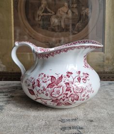 a red and white vase sitting on top of a table