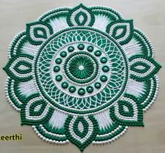 a green and white beaded doily with an intricate design