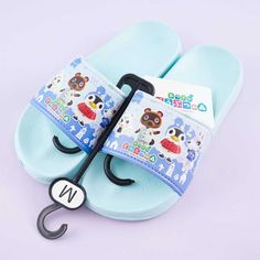 a pair of blue slippers with an umbrella on it's back and the letter n attached to them