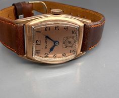 Rare 1940s original BULOVA CURVEX TANK with brand new brown saddle leather strap and with a very well preserved Curvex glass, with sought-after, salmon-colored original dial with black, Arabic indexes and original, blued steel pointers. Original legendary BULOVA caliber 10BC with 15 jewels, watch runs perfectly for it's age. Worth collecting, original timeless classic in good condition! Vintage Formal Watch With Leather Strap, Vintage Watches With Leather Strap And Rectangular Dial, Vintage Watch With Leather Strap And Rectangular Dial, Brown Retro Formal Watch, Classic Brown Watch With Waxed Finish, Vintage Brown Watch With Rectangular Dial, Vintage Brown Watches With Leather Strap, Vintage Brown Watch With Leather Strap, Vintage Brown Leather Watches