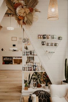 a living room filled with lots of furniture and shelves next to a wall mounted plant