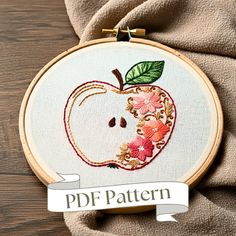 an embroidered apple with leaves and flowers on it