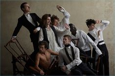 a group of young men and women posing for a photo in formal wear with their arms up