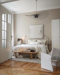 a bedroom with a bed, two chairs and a coffee table