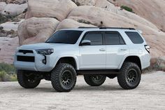 a white truck parked in front of some rocks