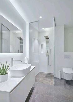 a white bathroom with two sinks and a large mirror on the wall next to it