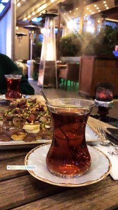 there is a tea cup and plate on the table with food in front of it