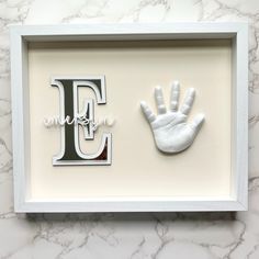 a white frame with a hand and the letter d on it