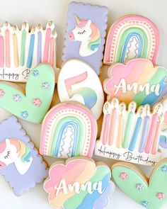 decorated cookies with unicorns, rainbows and numbers are arranged on a white surface