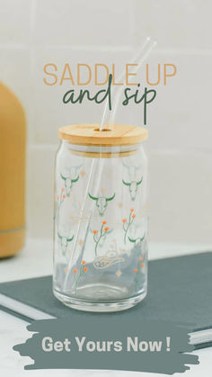 a glass jar with a straw in it and the words saddle up and sip on top