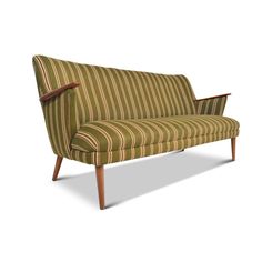 a green and brown striped couch with wooden legs