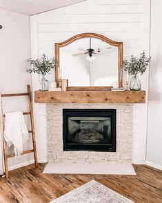 a living room with a fireplace and mirror on the mantel, next to a ladder