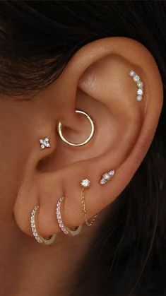 a woman's ear with three different types of piercings