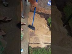 a person is using a broom to clean the sidewalk