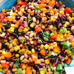 a blue bowl filled with black - eyed beans, carrots and cilantro