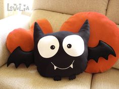 a black bat pillow sitting on top of a couch