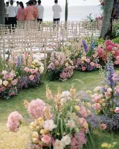 an outdoor ceremony with rows of chairs and flowers