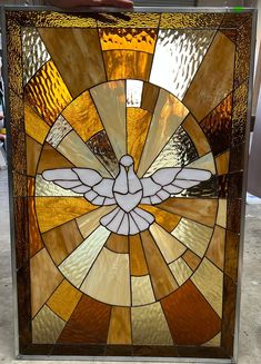 a close up of a stained glass window with a bird on it's side