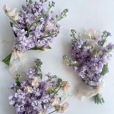 three bouquets of lavender flowers on a white surface