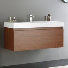 a white sink sitting under a mirror next to a wall mounted faucet in a bathroom