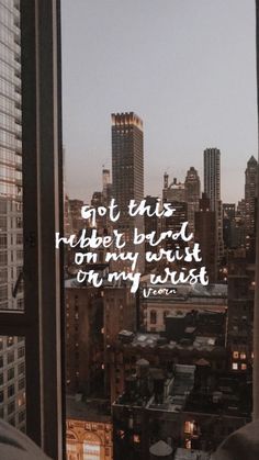 a city view from a window with a quote written on it