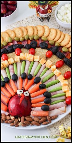 a turkey made out of crackers and vegetables on a platter with other snacks