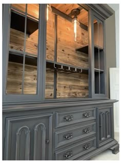 a large gray china cabinet with two lights on it's top and bottom shelves