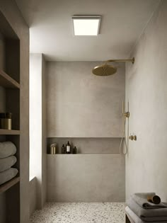 a walk in shower sitting next to a shelf filled with towels