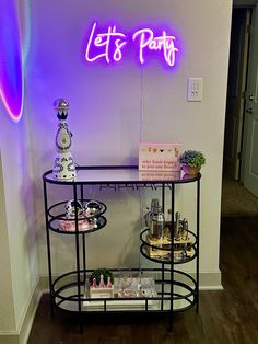 a table that has some items on it and a neon sign in the back ground