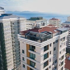 an aerial view of some buildings with the ocean in the background