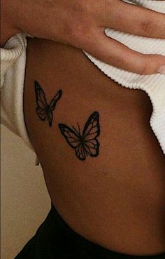 a woman with a butterfly tattoo on her stomach