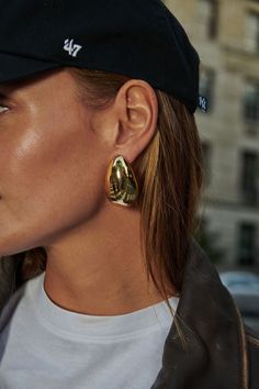 Make a Statement with Every Wear | Gylden Earrings Discover the bold elegance of the Gylden Earrings from Oma The Label. These large, teardrop-shaped earrings offer a modern and striking alternative to the Ewa hoops, with their unique dome-like design that adds a touch of contemporary flair. Perfect for making a statement, the Gylden Earrings will enhance any outfit with their standout presence and sophisticated style. Features: STMNT Collection: Part of the STMNT Collection, designed for those Gold Statement Earrings Outfit, Statement Accessories Outfit, Stackable Earring Ideas, Yellow Gold Teardrop Hoop Earrings, Modern Gold Teardrop Crown Earrings, Modern Teardrop Earrings With Crown, Modern Gold Pear-shaped Earrings, Modern Pear-shaped Earrings, Big Earrings Statement