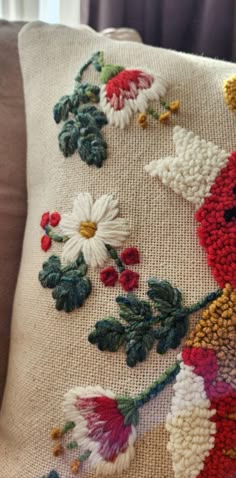 an embroidered pillow with flowers on it