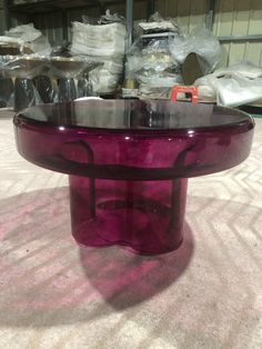 a purple glass table sitting on top of a carpet