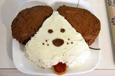 there is a plate with some cake shaped like a dog's head on it