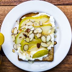 a white plate topped with toast covered in fruit and nuts