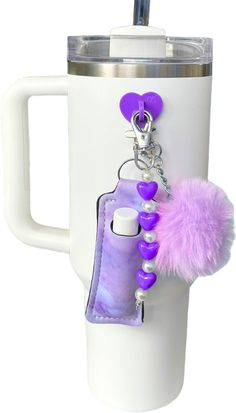 a cup with a keychain attached to it and a pom - pom hanging from the handle