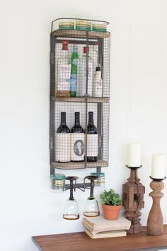 a shelf with bottles and candles on top of it next to a chair in front of a wall