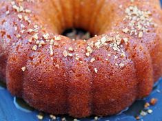 a bundt cake on a blue plate with sprinkles and sesame seeds