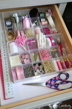 a drawer filled with lots of different types of crafting supplies and scissors on top of a table