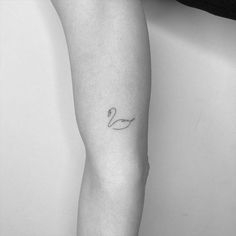 a black and white photo of a woman's leg with a tattoo on it