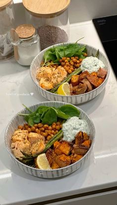 two tins filled with food sitting on top of a counter