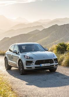 a silver porsche cayen is parked in the mountains