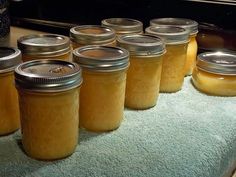 several jars filled with yellow liquid sitting on top of a blue towel next to an oven