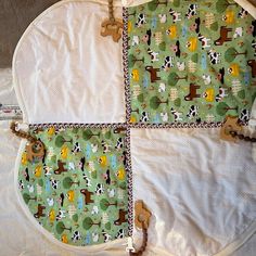 an oven mitt is sitting on top of a quilted tablecloth with animals and trees