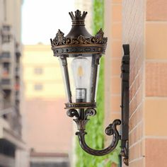 an old fashioned street light on the side of a building