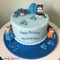 a birthday cake decorated with cats and yarn