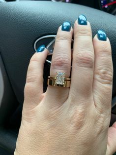 a woman's hand on the steering wheel of a car with a diamond ring